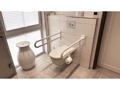 Rollstuhlgerechte Unterkunft - Unterkunftsart: Ferienhaus - Toilette mit Haltegriffen (rechter, vorderer Griff hochklappbar) - Landhaus Wilkens