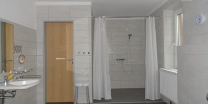 Rollstuhlgerechte Unterkunft - Nordseeküste - Behindertengerechtes Badezimmer mit großer Dusche und Duschhocker - Ferienhaus Amelsberg