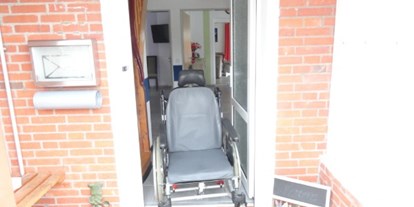 Rollstuhlgerechte Unterkunft - Niedersachsen - Beispielfoto mit einem Pflegerollstuhl in der Eingangstür vom Ferienhaus - Ferienhaus Amelsberg