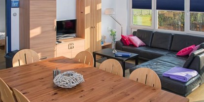 Rollstuhlgerechte Unterkunft - Niederlande - Esstisch und gemütliche Couch des Ferienhauses - Modestia Groepsverblijf Texel