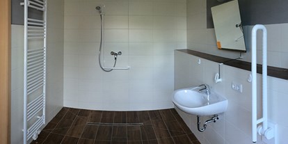 Rollstuhlgerechte Unterkunft - Ostsee - Ferienhof Lamp Badezimmer mit ebenerdiger Dusche und klappbaren Haltegriffen - Rollstuhlgerechte Unterkünfte im Ferienhof Lamp