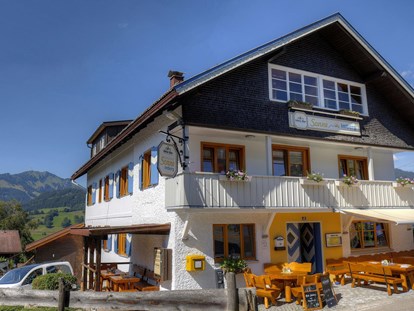 Rollstuhlgerechte Unterkunft - Bayern - Hauptansicht Berggasthof Sonne mit Biergarten und im Hintergrund der Grünten der "Wächter des Allgäu" - Pflegehotel Allgäu