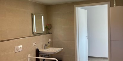 Rollstuhlgerechte Unterkunft - Baden-Württemberg - Die Toilette mit klappbaren Stützgriffen - Ferienwohnung Westweg