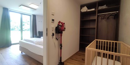 Rollstuhlgerechte Unterkunft - Bayern - begehbares Schrankzimmer bzw Babyzimmer mit Babybettchen (kann auch ins Elternschlafzimmer gestellt werden) und Kinderhochstuhl - Erdhausapartment OST