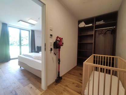 Rollstuhlgerechte Unterkunft - Bayern - begehbares Schrankzimmer bzw Babyzimmer mit Babybettchen (kann auch ins Elternschlafzimmer gestellt werden) und Kinderhochstuhl - Erdhausapartment WEST